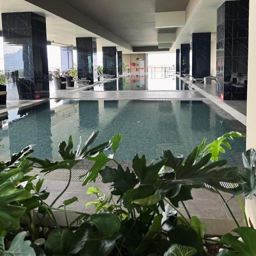 a swimming pool in a building with green plants at IPOH City Centre ICC Suites by HWC in Ipoh