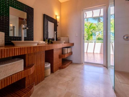 a bathroom with two sinks and a large mirror at Casa White#2 Beautiful modern beach house in Sámara