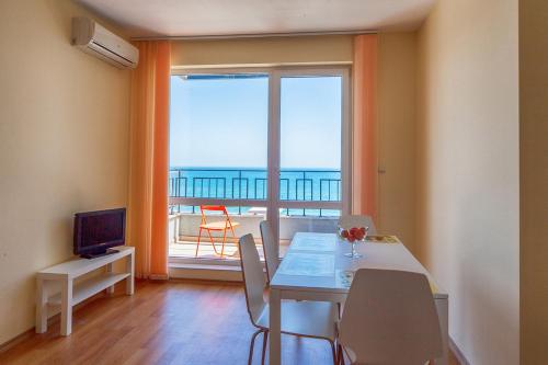 a dining room with a table and a view of the ocean at Panorama Kabakum Apartments - Free Parking in Golden Sands