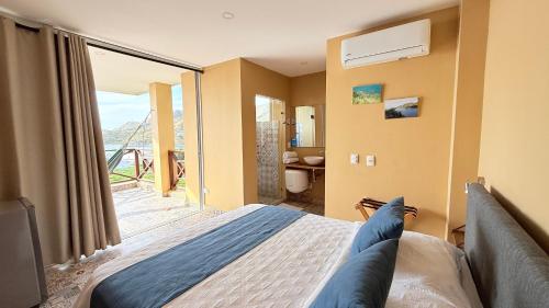 a bedroom with a bed and a large window at Cabañas Paraiso in Taganga