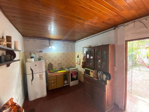 a small kitchen with a refrigerator and a stove at Casa Zorzal in Paso de la Patria