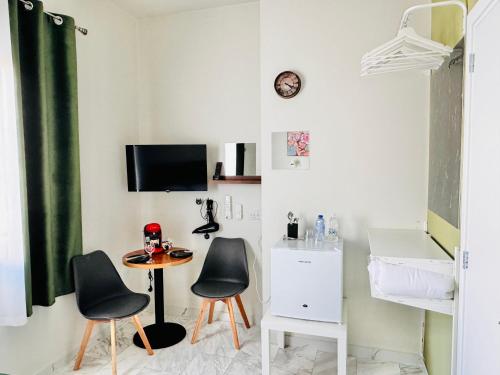 Pokój z dwoma krzesłami, stołem i telewizorem w obiekcie Smart Comfort RoomN2 with Private Bathroom in best Location Beach 250m w mieście Limassol