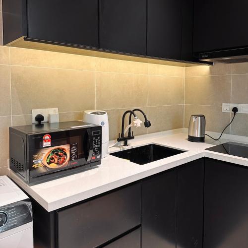 a kitchen with a microwave with a pizza on it at IPOH City Centre ICC Suites by HWC in Ipoh
