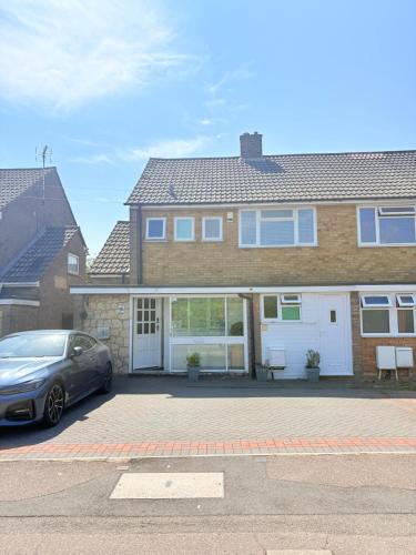 a car parked in front of a house at EasyStay - Bright & Spacious house, recently renovated, Free Parking near Luton Airport in Luton