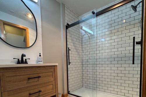 a bathroom with a shower with a sink and a mirror at Crestview Ski Condo in Winter Park