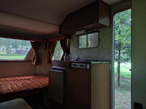 a small kitchen in an rv with a window at Le Lièvre et La Tortue in La Chaise-Beaudouin
