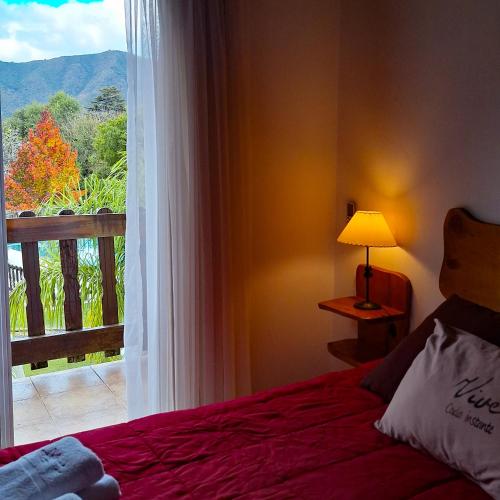 a bedroom with a bed and a window with a view at Posada Yumei in Villa General Belgrano