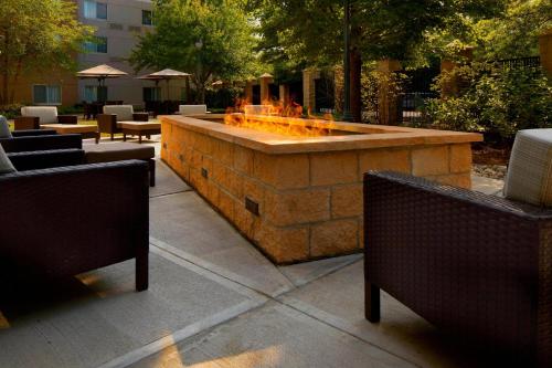 a large stone fountain in a patio with tables and chairs at Courtyard Edison Woodbridge in Edison