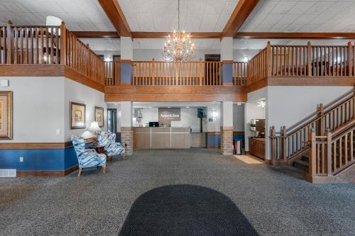 a large lobby with stairs and a chandelier at AmericInn by Wyndham Green Bay East in Green Bay
