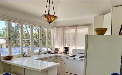 a kitchen with white appliances and a large window at The Treehouse in Sarasota