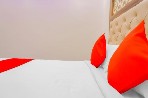 a bedroom with a bed with red pillows on it at Hotel O Rest Inn in Yeraoda