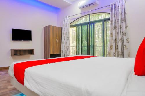 a bedroom with a bed and a large window at Hotel O Rest Inn in Yeraoda