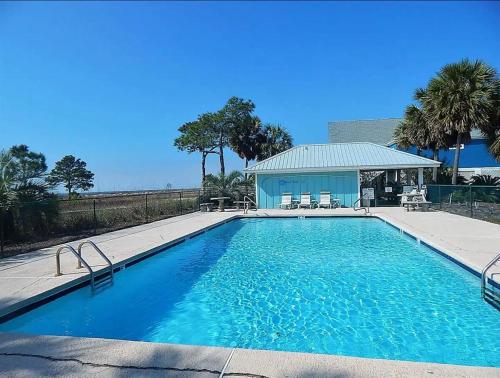 a large blue swimming pool with a gazebo at Sunset Sanctuary in Dauphin Island