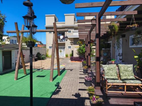 a backyard with a green lawn and a pergola at Pousada Rota dos Mares in Penha