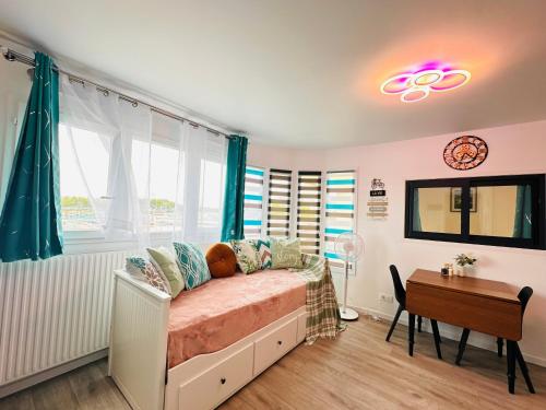 a bedroom with a bed and a table and a window at Appartement Bonheur Disneyland Paris in Torcy