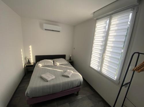 a small bedroom with a bed and a window at Studio calme climatisé, Wi-Fi, arrivée autonome in Douai