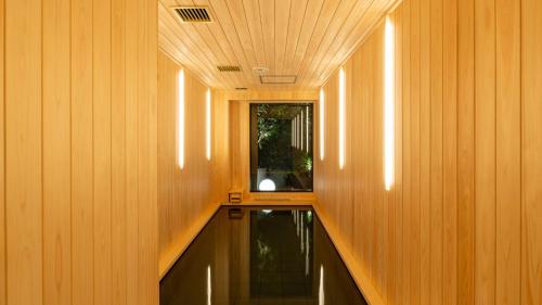 a hallway with wood paneled walls and a mirror at OUR OUR - CAFE - MINIMAL HOTEL - Vacation STAY 56660v in Tokyo
