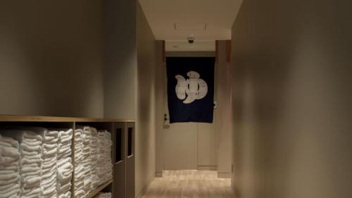 東京にあるOUR OUR - CAFE - MINIMAL HOTEL - Vacation STAY 56656vの旗が掲げられた壁のある廊下