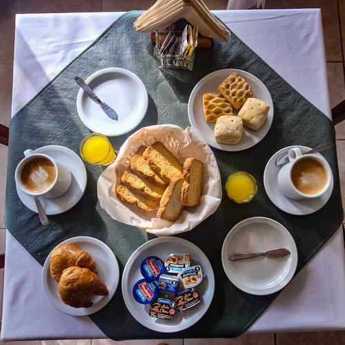 a table with plates of food and cups of coffee at Posada Yumei in Villa General Belgrano