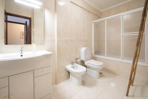 a bathroom with a toilet and a sink at Cozy Traveller Apartment & Garage in Aveiro