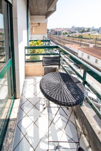 a patio with a table and chairs on a balcony at Cozy Traveller Apartment & Garage in Aveiro