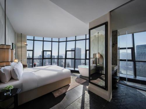 a bedroom with a large bed and a bath tub and a bathroom at Chongqing KS Kongshang Hotel in Chongqing