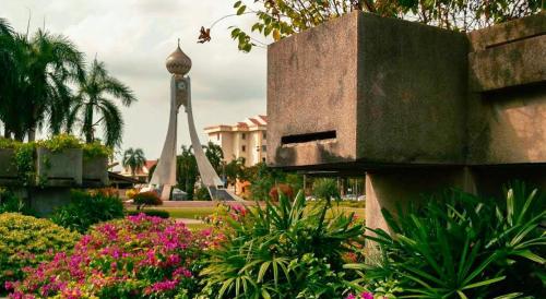 a clock tower in the middle of a park with flowers at IPOH City Centre ICC Suites by HWC in Ipoh