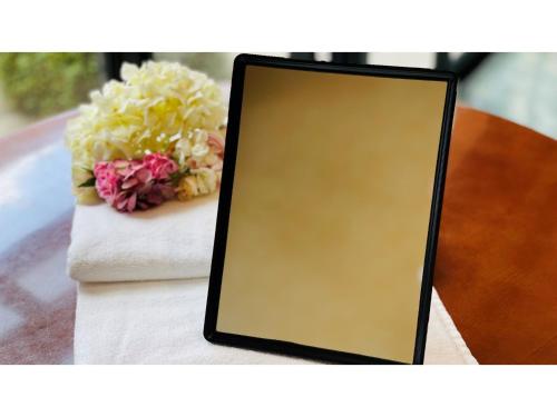 a mirror sitting on a table with a vase of flowers at Shinyokohama Kokusai Hotel - Vacation STAY 62852v in Yokohama