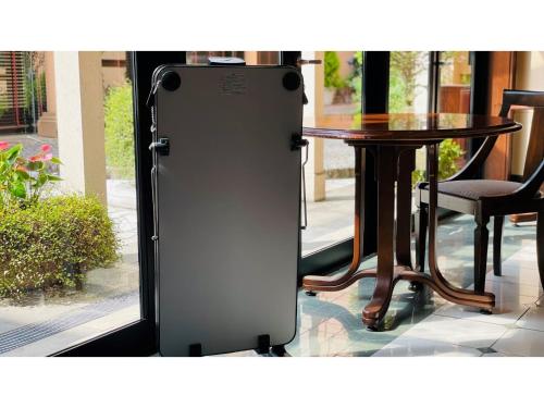 a refrigerator is standing in front of a table at Shinyokohama Kokusai Hotel - Vacation STAY 62845v in Yokohama