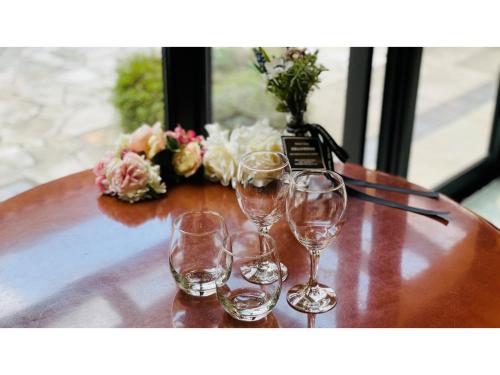 três copos de vinho sentados numa mesa com flores em Shinyokohama Kokusai Hotel - Vacation STAY 62807v em Yokohama