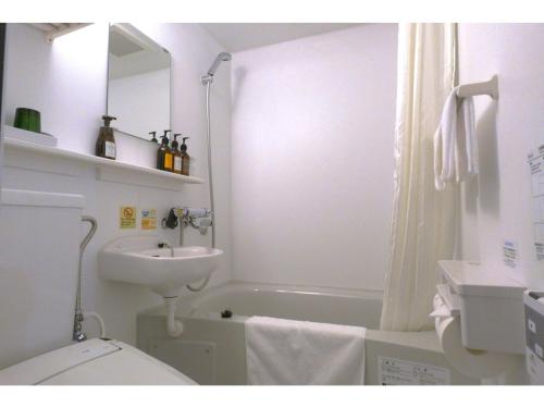 a bathroom with a sink and a toilet and a bath tub at Smile Hotel Kushiro - Vacation STAY 69852v in Kushiro