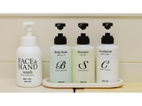 a group of four bottles of laundry detergents on a shelf at Smile Hotel Nagoya Shinkansenguchi - Vacation STAY 77730v in Nagoya