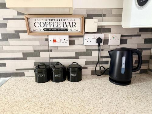 a coffee bar with three coffee pots on a counter at Edgbaston Retreat-Birmingham City Centre-Double Room in a shared two bedroom apartment in Birmingham