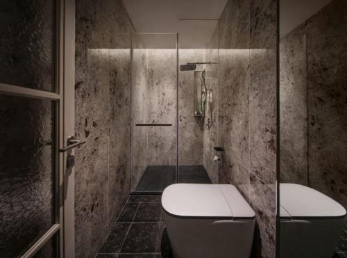 a bathroom with a toilet and a glass shower at Chongqing KS Kongshang Hotel in Chongqing