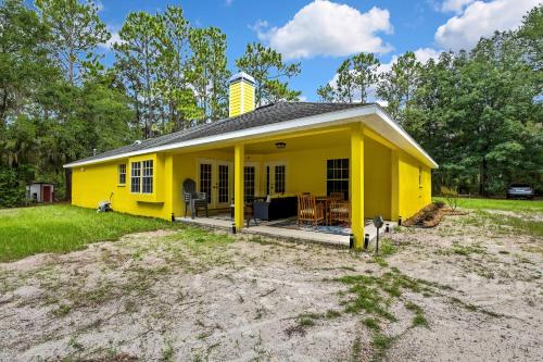 a yellow house with a patio in a yard at Cozy Cottage in Crystal River in Crystal River