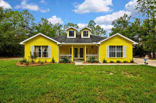 a yellow house with a green lawn at Cozy Cottage in Crystal River in Crystal River