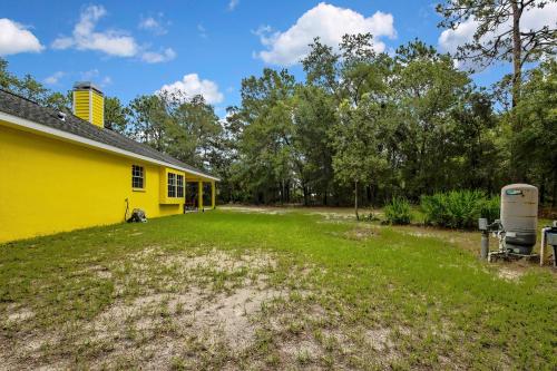 a yellow house with a trailer in the yard at Cozy Cottage in Crystal River in Crystal River