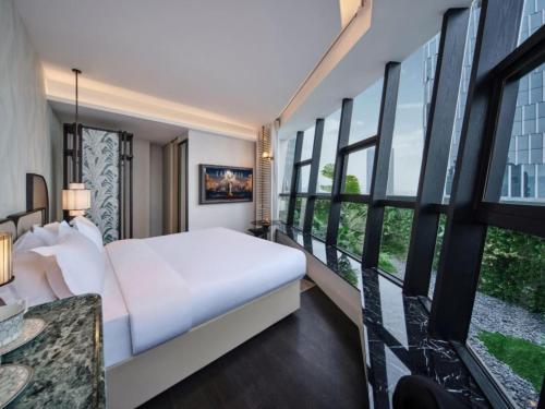 a bedroom with a white bed and large windows at Chongqing KS Kongshang Hotel in Chongqing