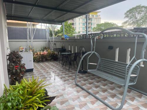 a green bench sitting on top of a patio at The Hydrangea House in Kota Kinabalu