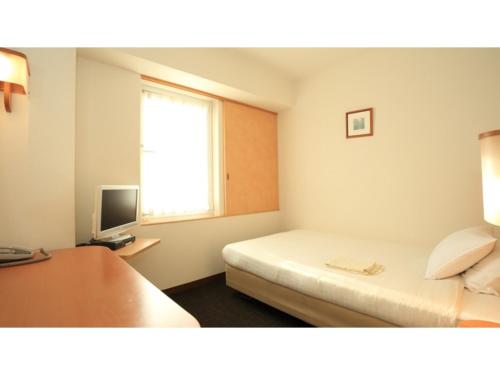 a hotel room with a bed and a television at Smile Hotel Shiogama - Vacation STAY 84737v in Shiogama