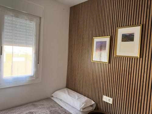a room with a striped wall with a pillow and a window at Oak Home - Oakplaces in León