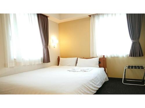 a bedroom with a white bed with two windows at Smile Hotel Kobe Motomachi - Vacation STAY 85861v in Kobe