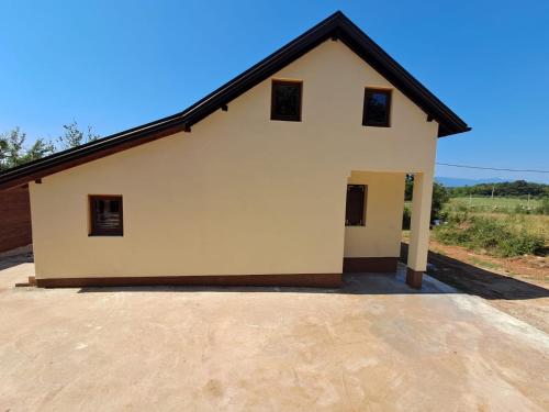 a large white building with a black roof at Villa Zora - Oaza mira u srcu Like in Gornja Ploča
