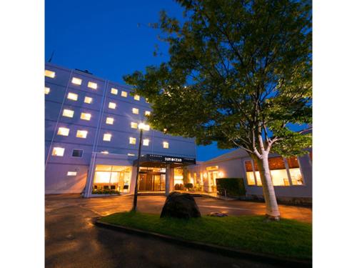 a building with a tree in front of it at Smile Hotel Anan - Vacation STAY 88776v in Anan