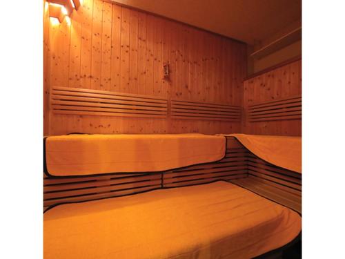 two beds in a room with wooden walls at Smile Hotel Anan - Vacation STAY 88749v in Anan