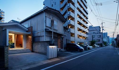 una strada cittadina con un edificio con auto parcheggiate sul lato di Otsu Guesthouse Seiseki - Vacation STAY 90442v a Otsu