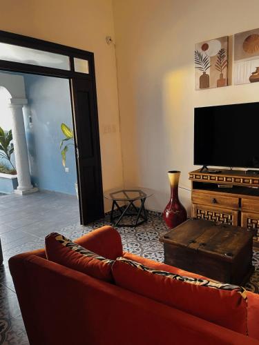 a living room with a couch and a television at Casa Tio Roger in Mérida