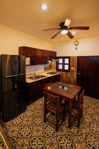 a kitchen with a table and a ceiling fan at Casa Tio Roger in Mérida