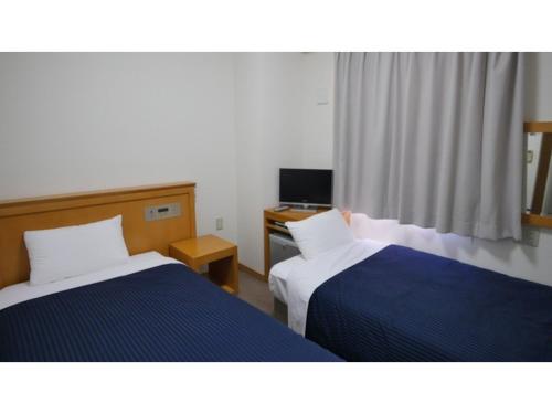 a hotel room with two beds and a desk at Smile Hotel Shizuoka Yoshida Inter - Vacation STAY 90908v 