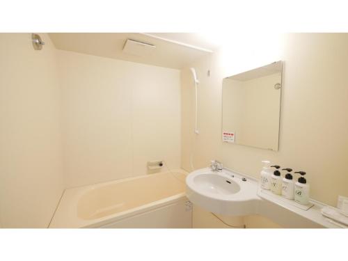 a bathroom with a sink and a toilet and a mirror at Smile Hotel Shizuoka Yoshida Inter - Vacation STAY 90880v 